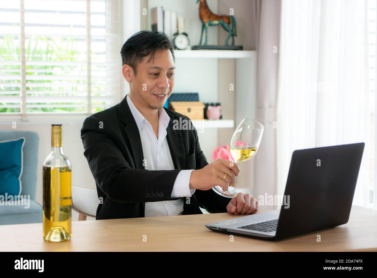 L'uomo asiatico Virtual Happy hour meeting party e bere vino bianco online insieme al suo amico in videoconferenza con il tablet digitale per un Foto Stock