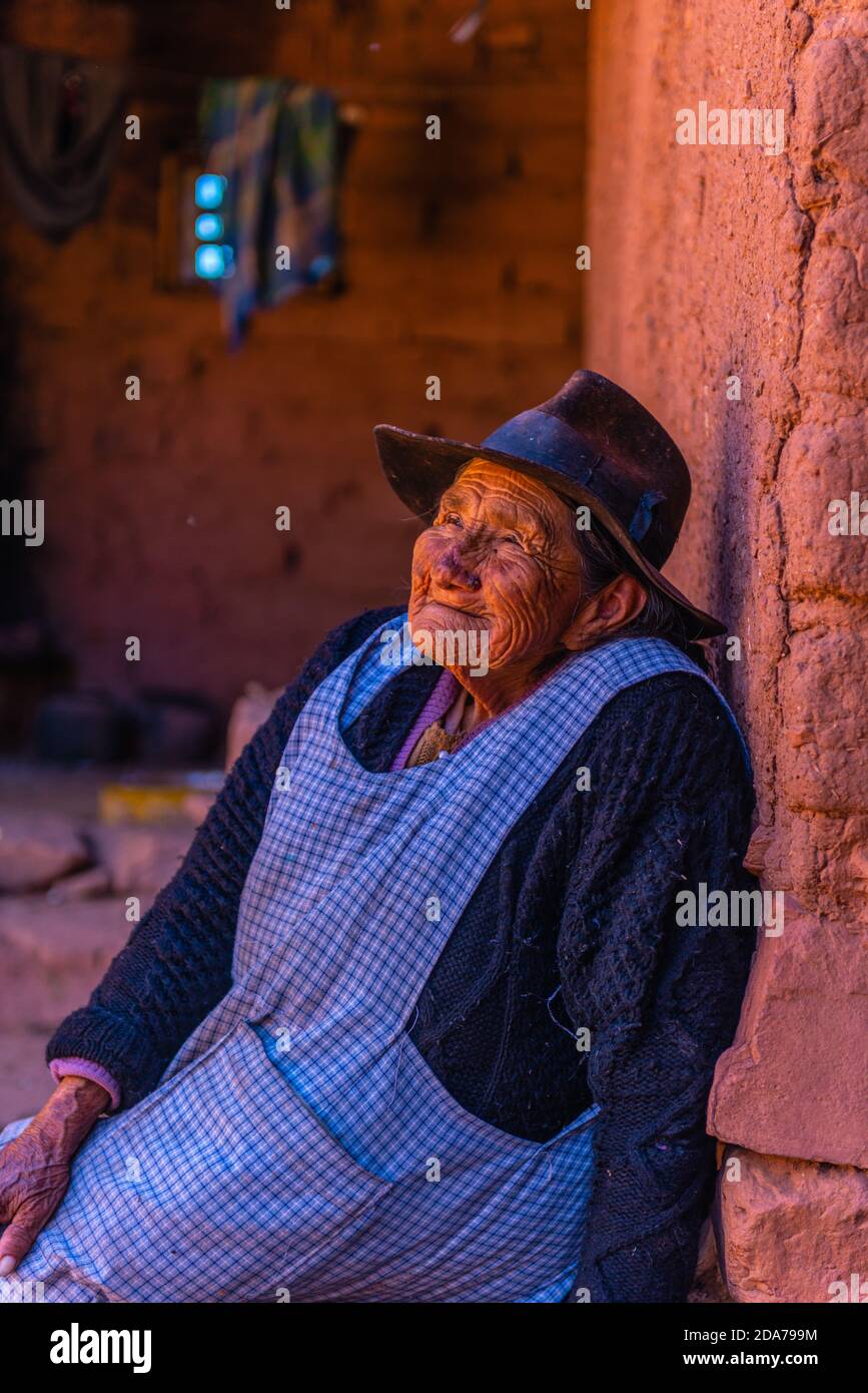 Molto vecchia donna locale nella corte interna della sua casa di adobe, Chaunaca, comune Sucre, Ande, Bolivia, America Latina Foto Stock