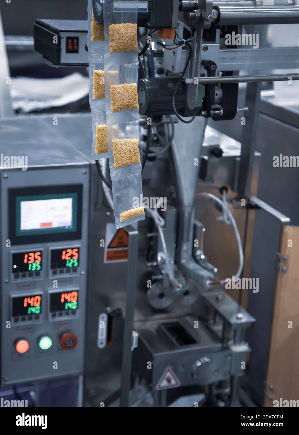 Macchina automatica di riempimento e sigillatura verticale. Macchine alimentari industriali Foto Stock