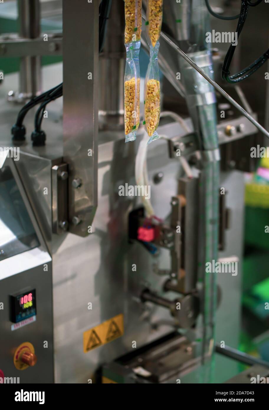 Confezionamento automatico di alimenti riempimento verticale e macchina di sigillatura. Macchine alimentari industriali Foto Stock
