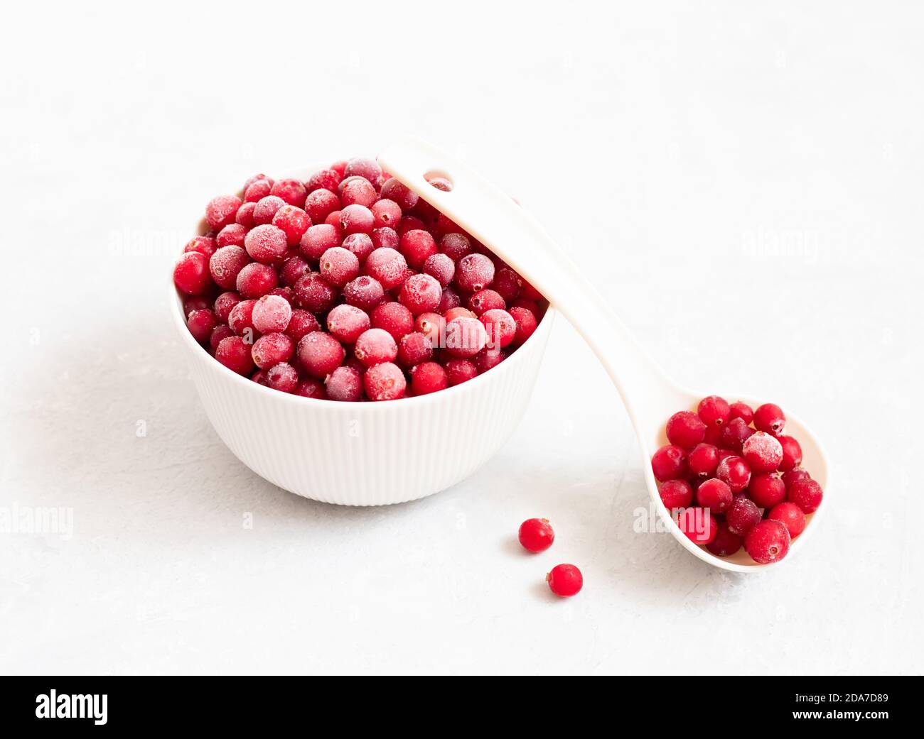 Mirtilli congelati su sfondo bianco da vicino. Bacche surgelate in un recipiente. Vista laterale. Foto Stock