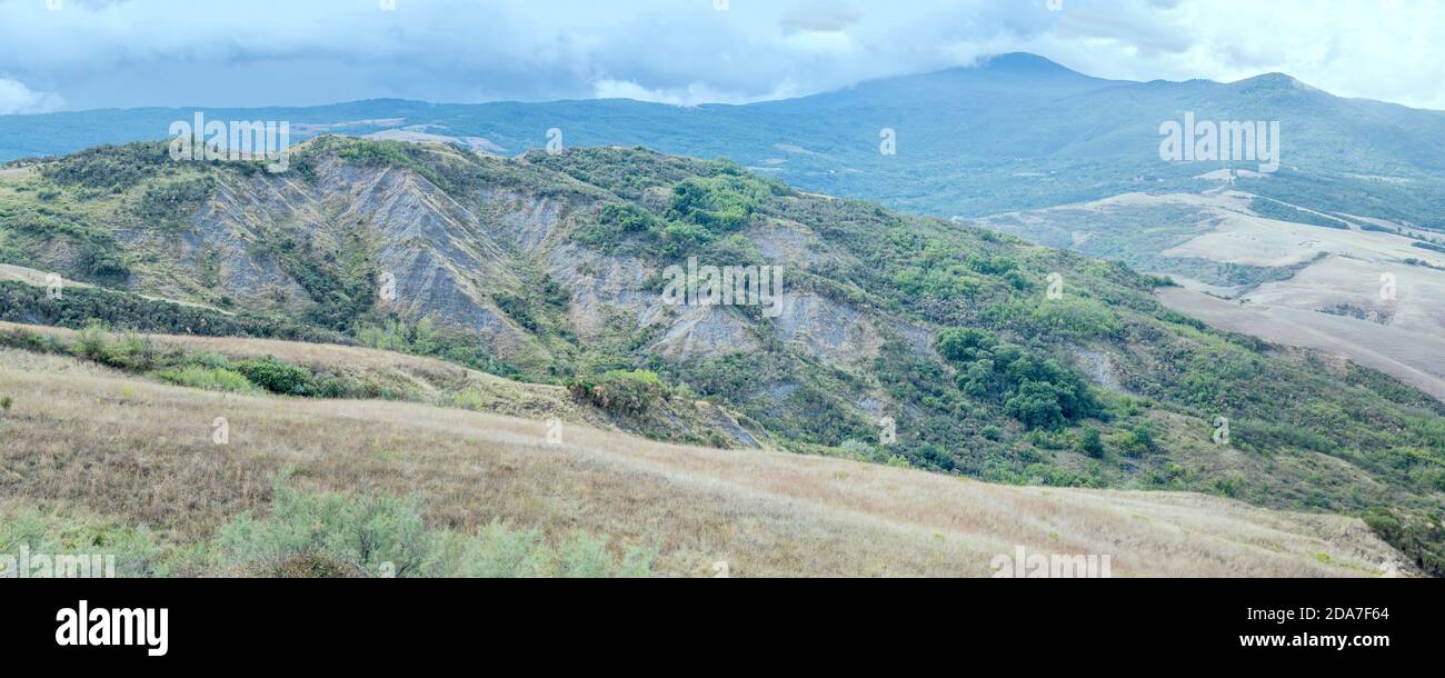 Paesaggio aereo con aspre calanques in verde valle di campagna collinare, girato in luce intensa nella valle dell'Orcia vicino a le Conie, Siena, Toscana, Italia Foto Stock