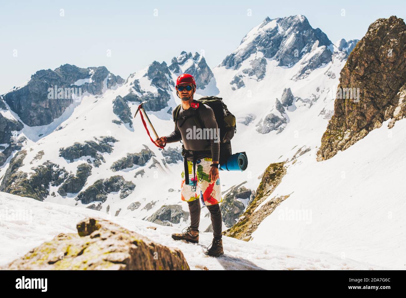Uomo arrampicatore che tiene l'ascia di ghiaccio sul concetto di lifestyle di corsa di montagna avventura vacanze attive extreme sport alpinismo all'aperto utilizzando equipe alpinismo Foto Stock