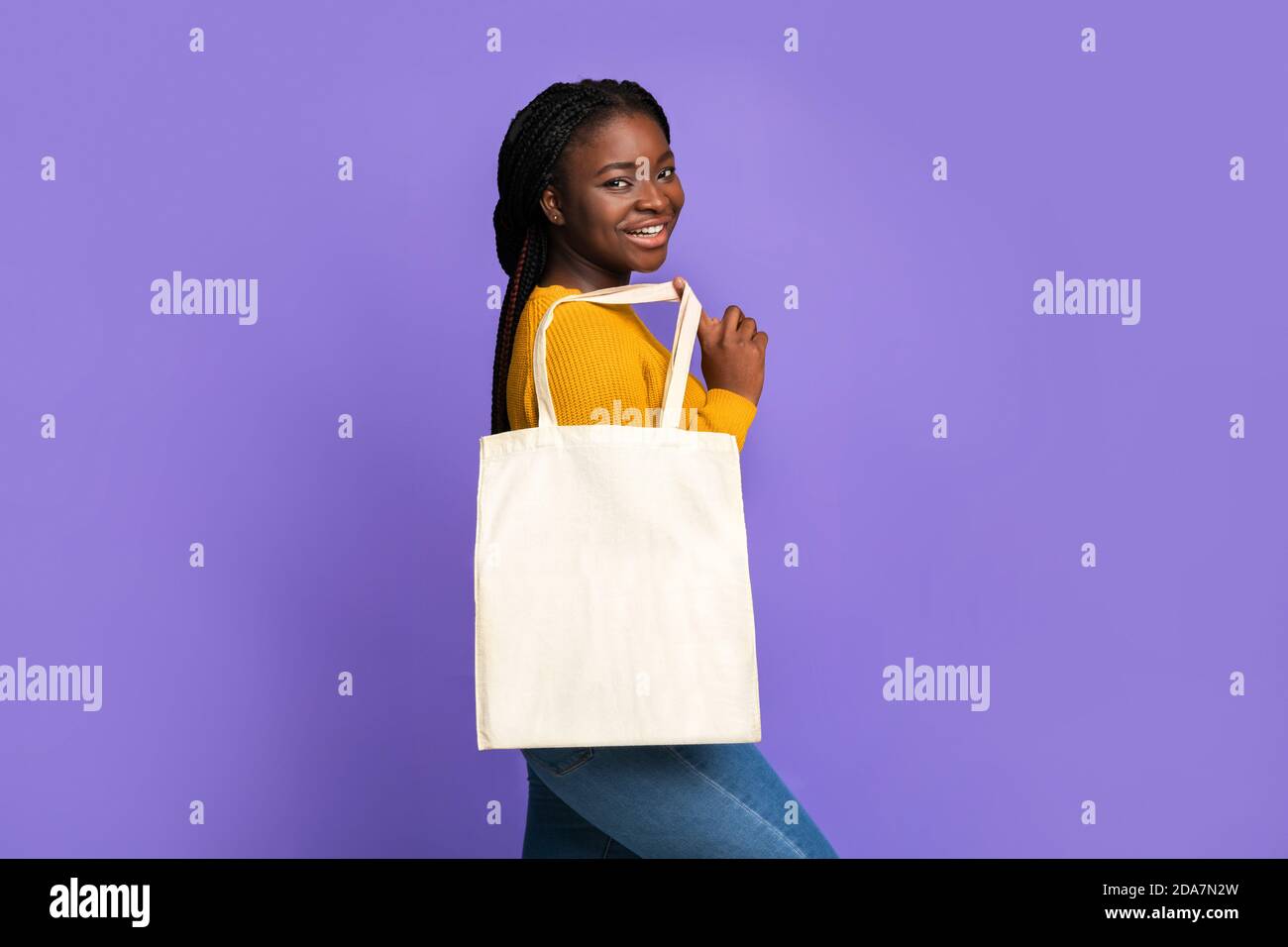Gioiosa donna africana in posa con borsa tote vuota con Mockup Per progettazione Foto Stock