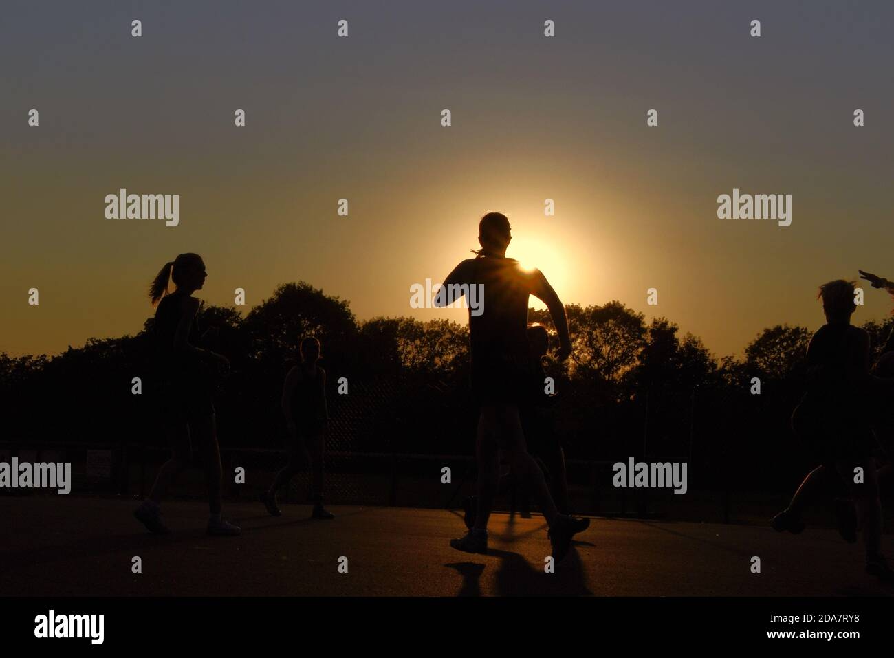 I giocatori di netball hanno la silhouette del sole che tramonta in questa foto Preso alla fine di un caldo settembre giorno in Surrey Foto Stock