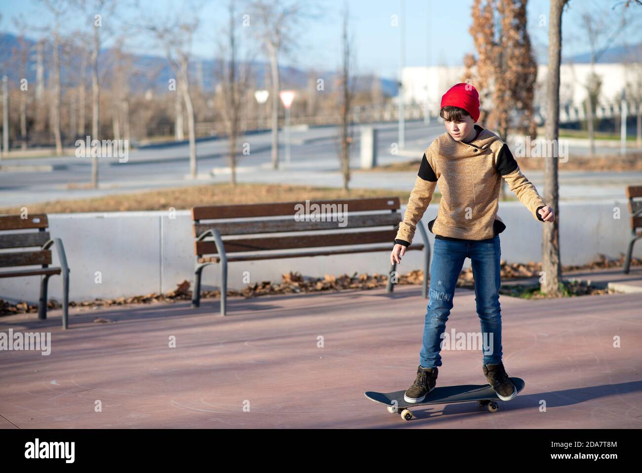 Skateboarder maschile a cavallo e pratica skateboard in città all'aperto Foto Stock