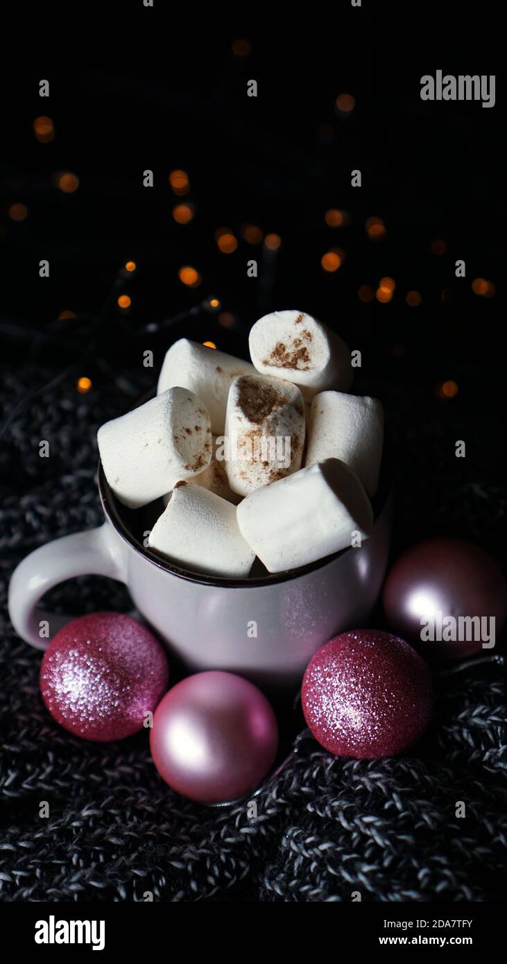 Cioccolato caldo di Natale con marshmallows su un tavolo con luci bokeh. Messa a fuoco selettiva - foto verticale Foto Stock