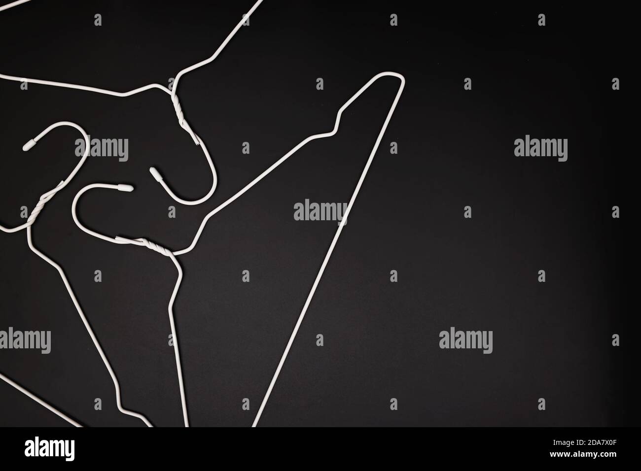 Appendiabiti bianchi vuoti su sfondo nero Foto Stock