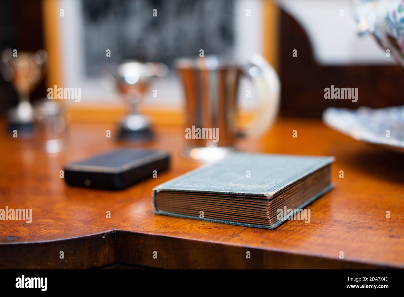 Piccolo vecchio libro su un tavolo laterale Foto Stock