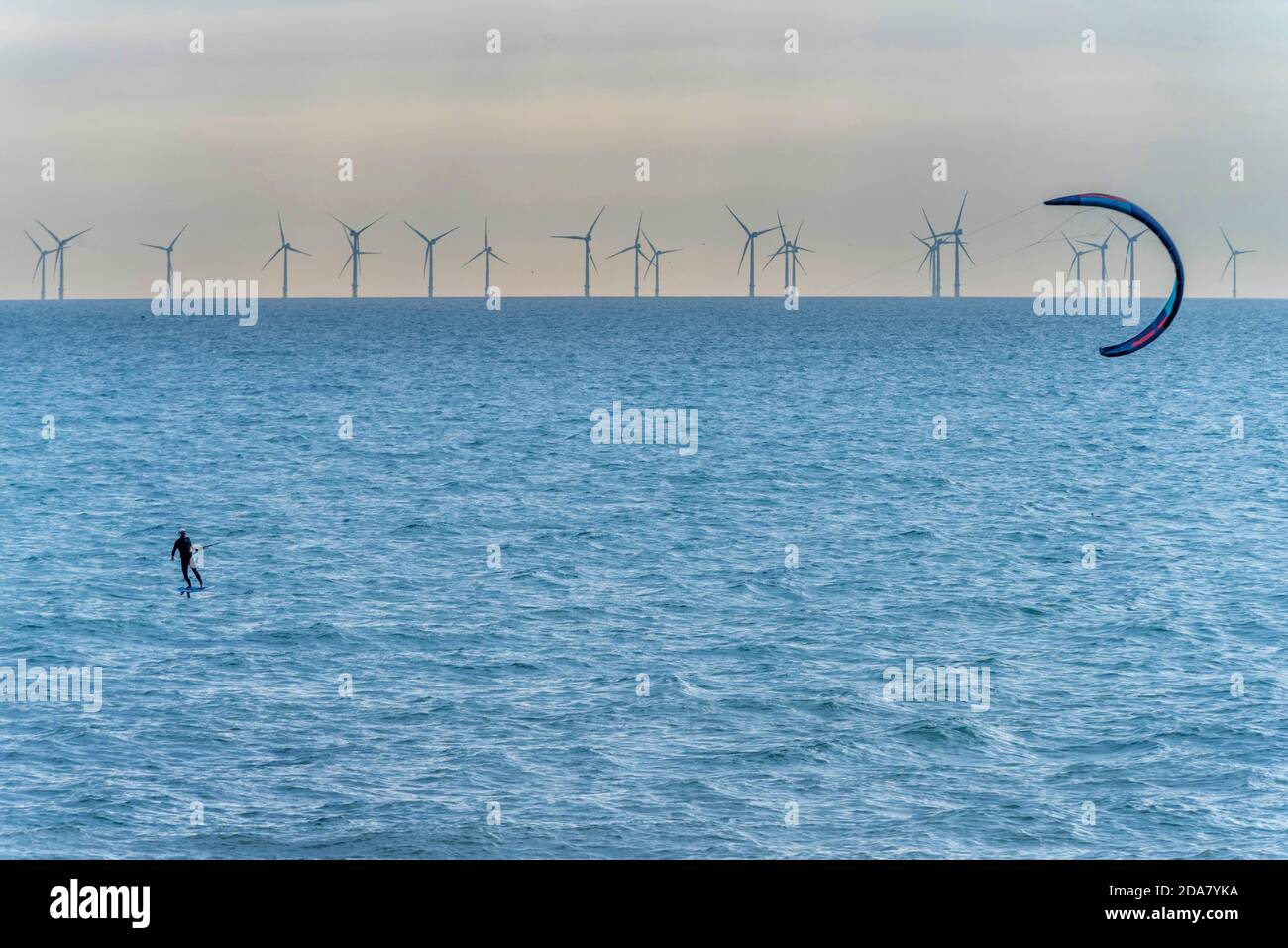 Brighton, 9 novembre 2020: Un kite-surfer al largo della costa di Sussex vicino Hove di fronte a Rampion Wind Farm, che celebrerà due anni di pro Foto Stock