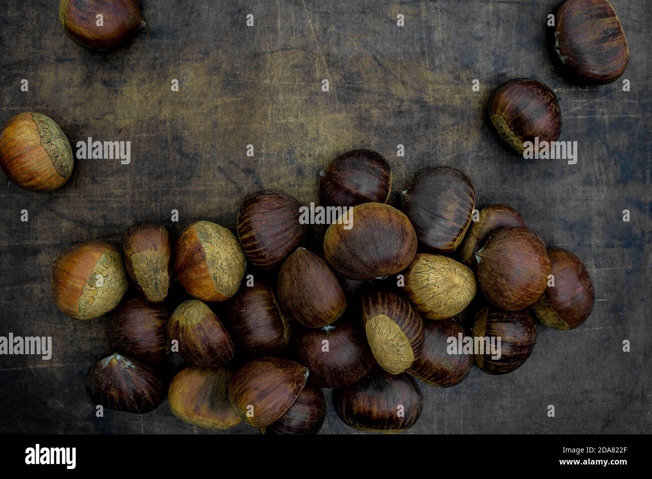 Castagne dolci crude adagiate su un piatto di gres, Castanea sativa Foto Stock