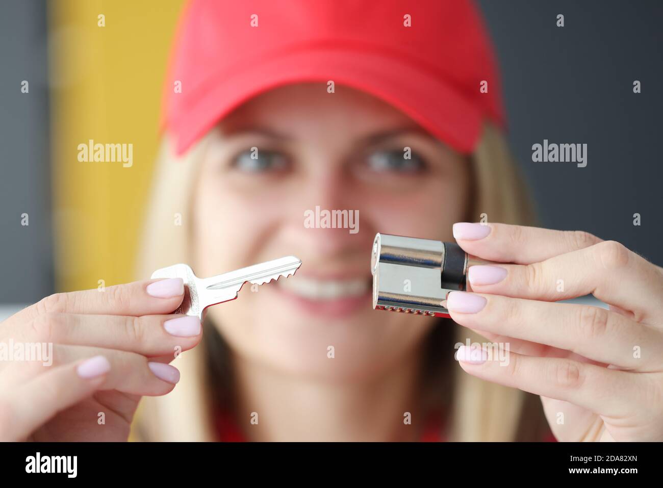 Ritratto di donna sorridente che tiene la serratura e la chiave in lei mani Foto Stock