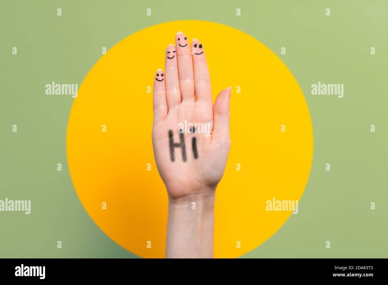 Giornata mondiale di saluto. Mano femminile rialzata con l'iscrizione Ciao. Verde con sfondo a sfera giallo. Spazio di copia. Foto Stock