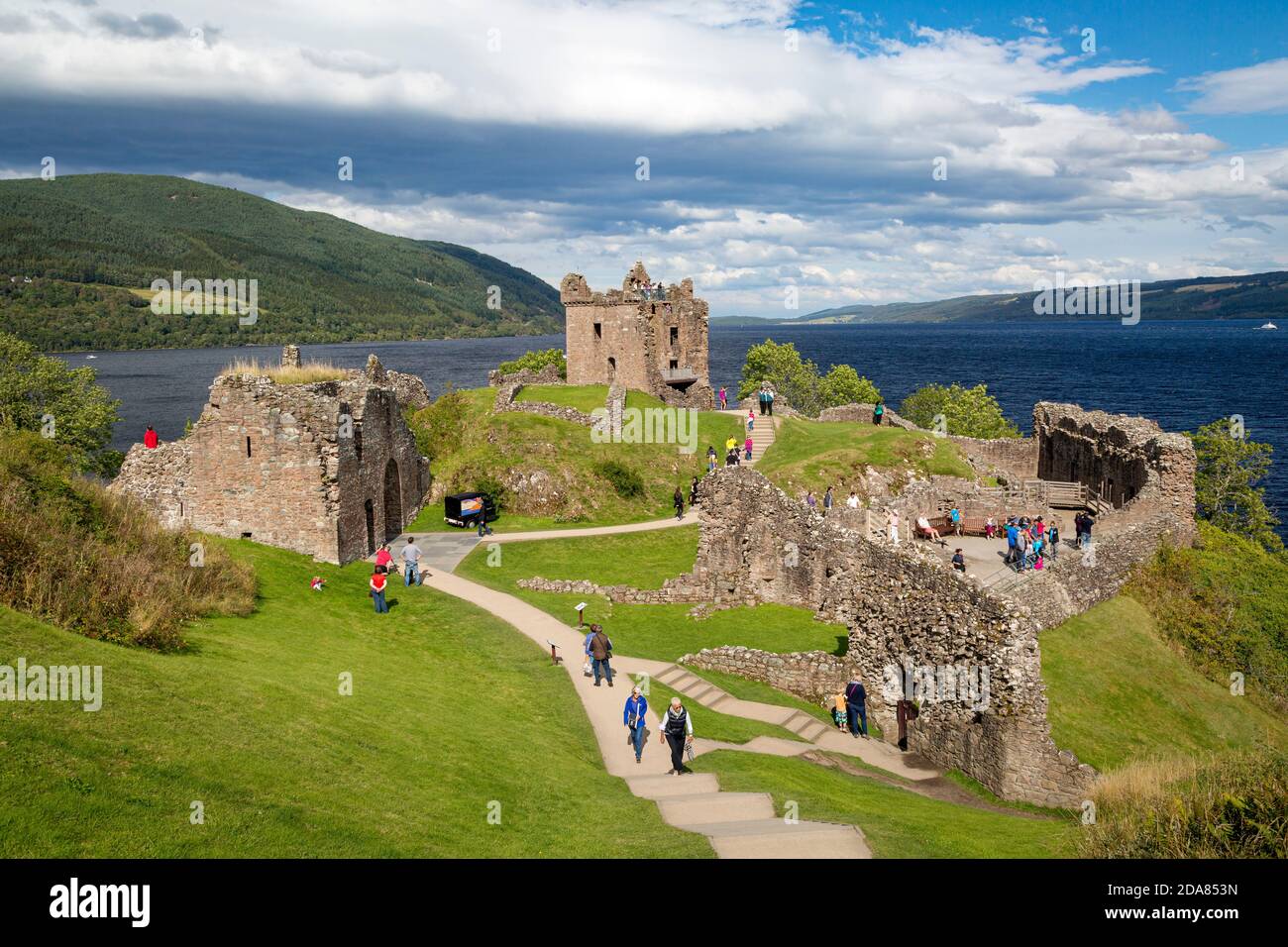 I turisti visitano le rovine del Castello di Urquhart lungo le rive del Loch Ness, Highlands, Scozia Foto Stock