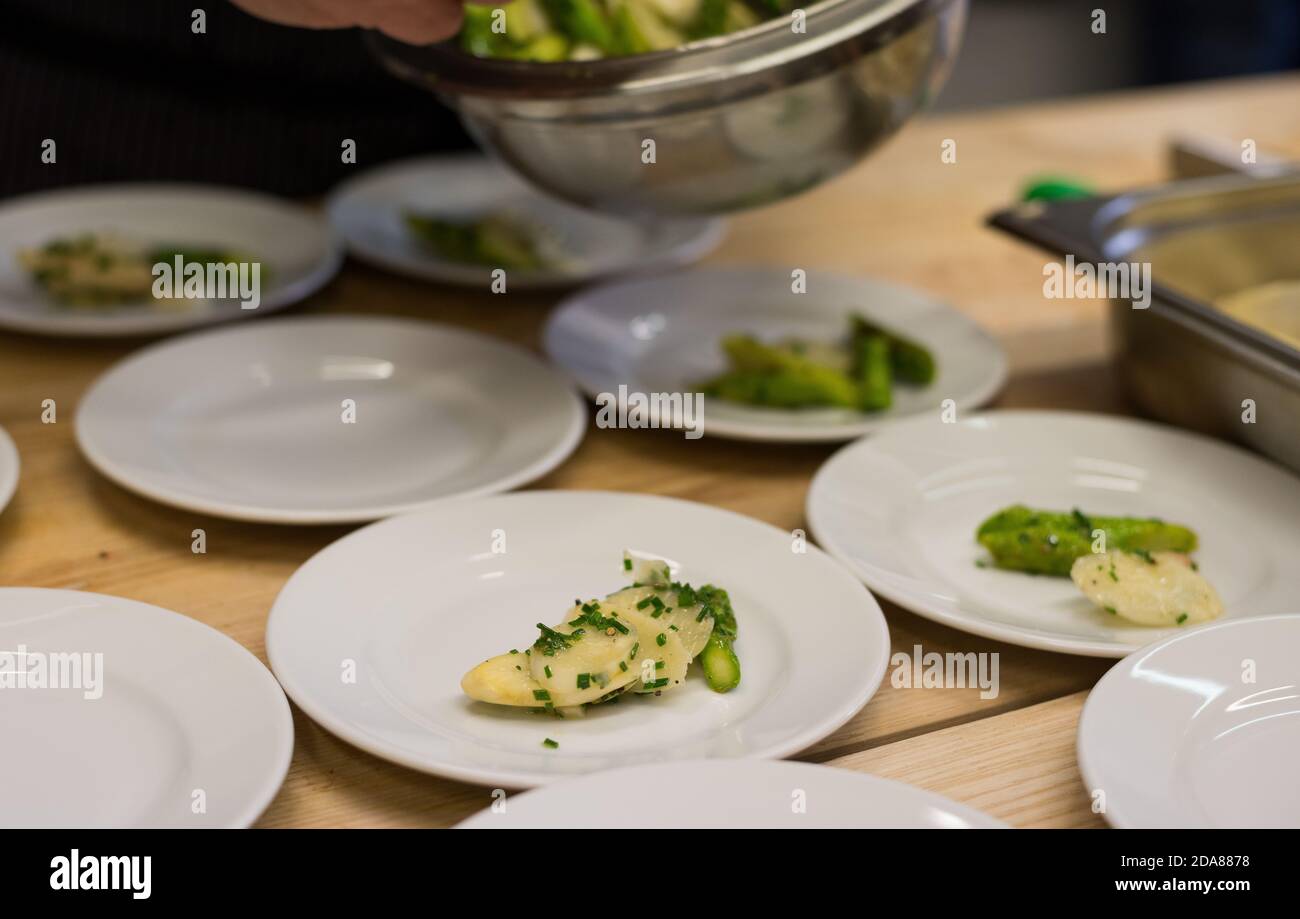Placcatura di asparagi bianchi e verdi su piccoli piatti come antipasto Foto Stock