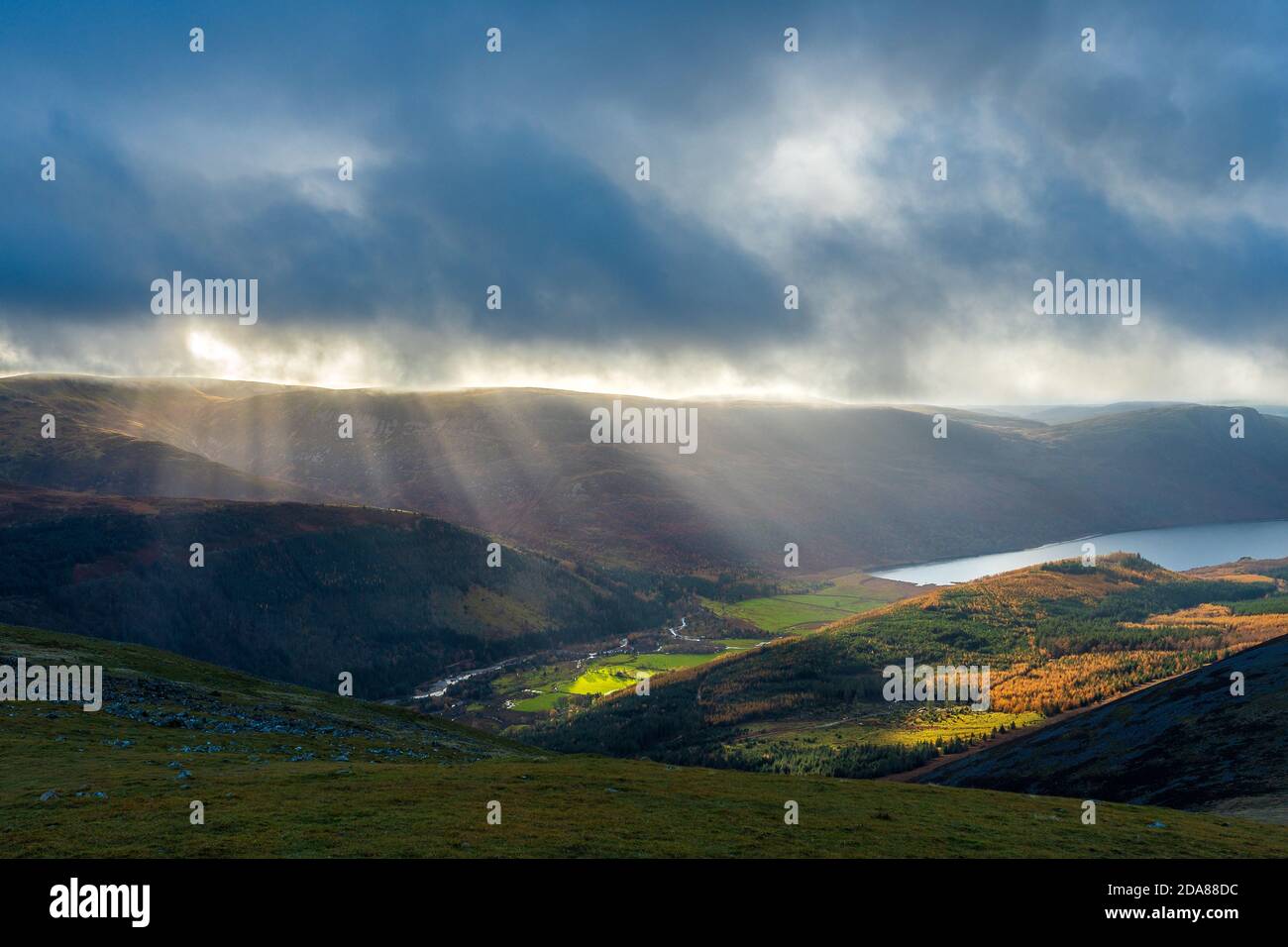 Raggi / alberi di luce solare attraverso le nuvole sopra l'acqua di Ennerdale. Lake District National Park, Cumbria, Regno Unito Foto Stock