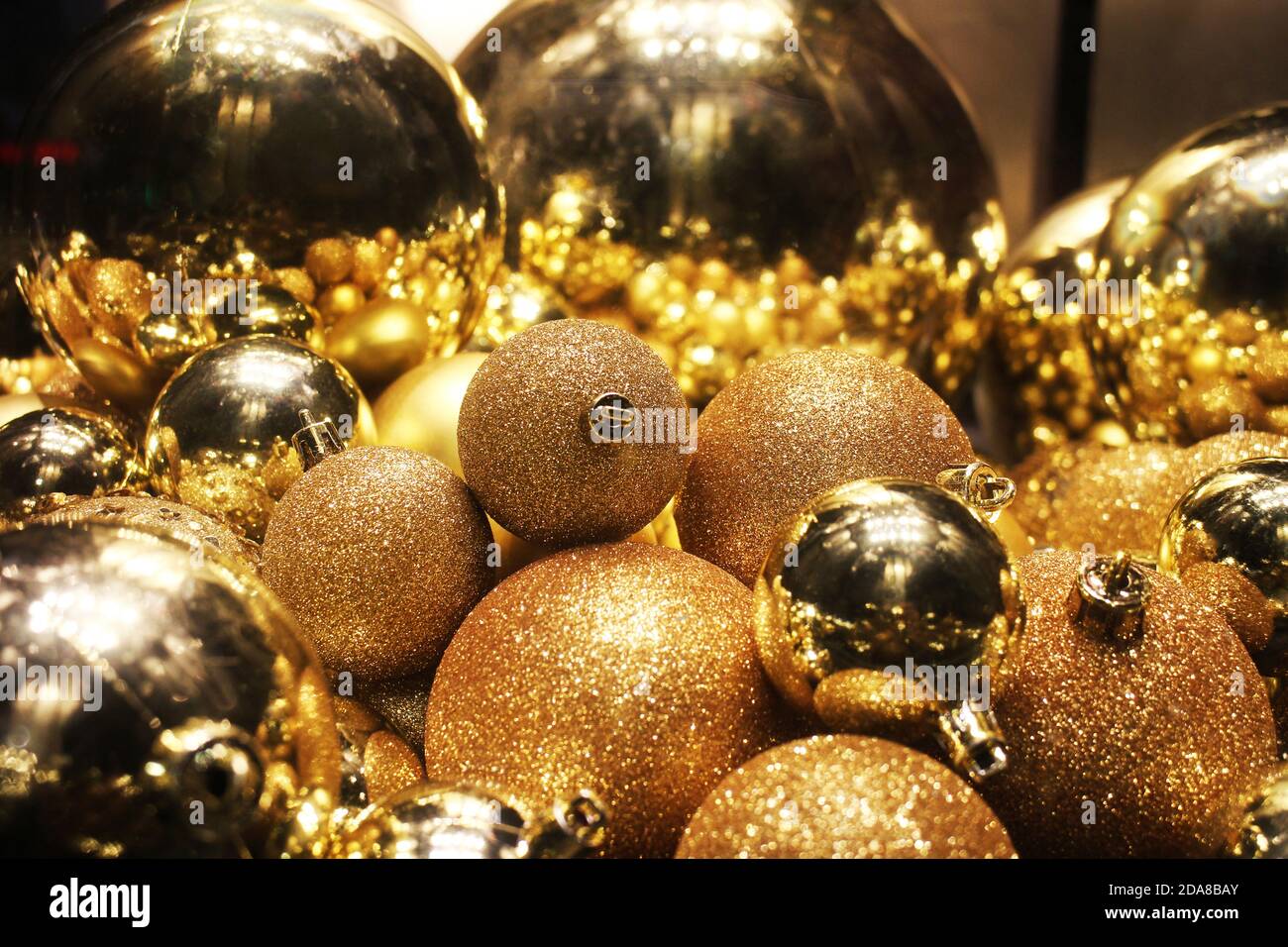 Molte sfere d'oro per la decorazione domestica di Capodanno per un atmosfera e atmosfera festosa Foto Stock