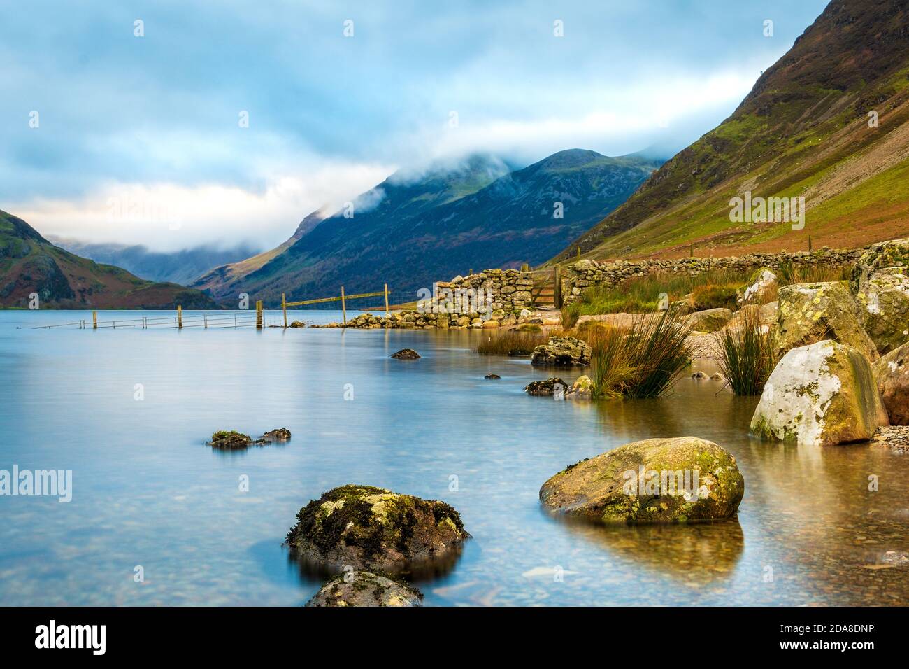 Crummock Water nel nord-ovest Lake District National Park, Cumbria. Le campane intorno a Buttermere in lontananza Foto Stock