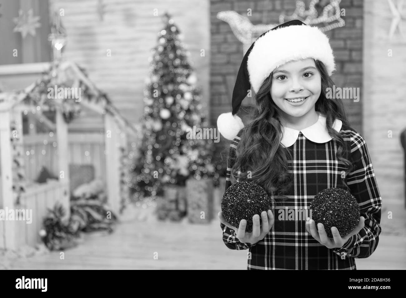 Capretto alla moda decorativa palla di Natale. la felicità e allegria. mattina prima di natale. Felice anno nuovo. sorridente bambino in santa hat. vacanze inverno attività. shopping natalizio. piccola ragazza elf costume. Foto Stock