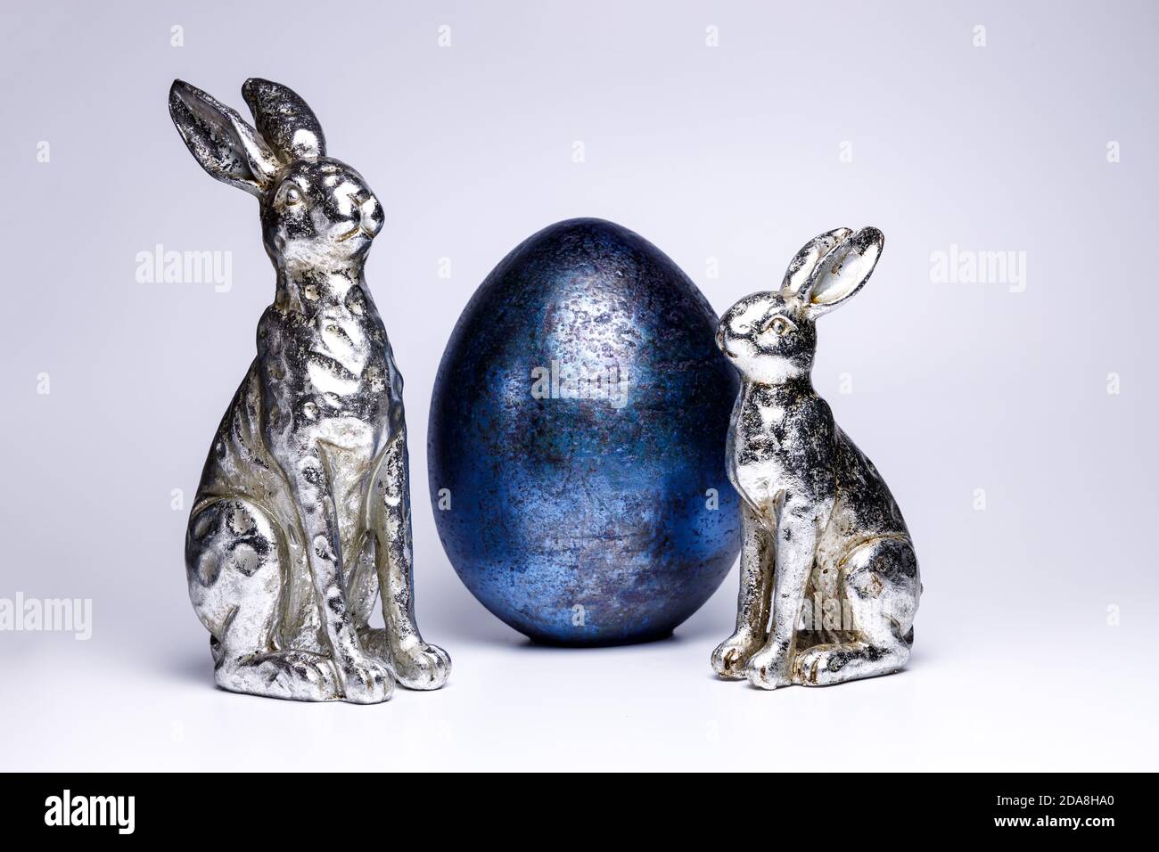 due figure realistiche di un coniglietto pasquale e di un uovo di pasqua blu reale, decorazione creativa di pasqua e primavera 2020, colori di tendenza su bianco isolato backg Foto Stock
