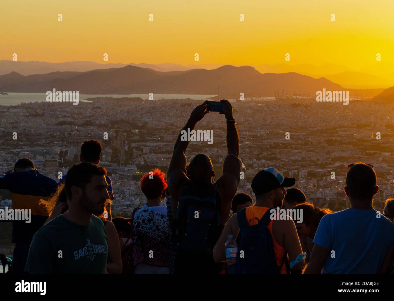 I turisti scattano foto sui loro smartphone al punto di osservazione sulla collina di Lycabettus nel centro di Atene Grecia - Foto: Geopix Foto Stock