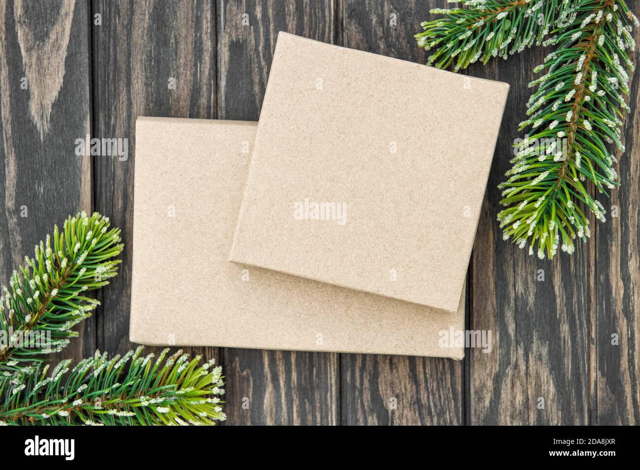 Scatole regalo di Natale carta artigianale che avvolge su sfondo di legno Foto Stock