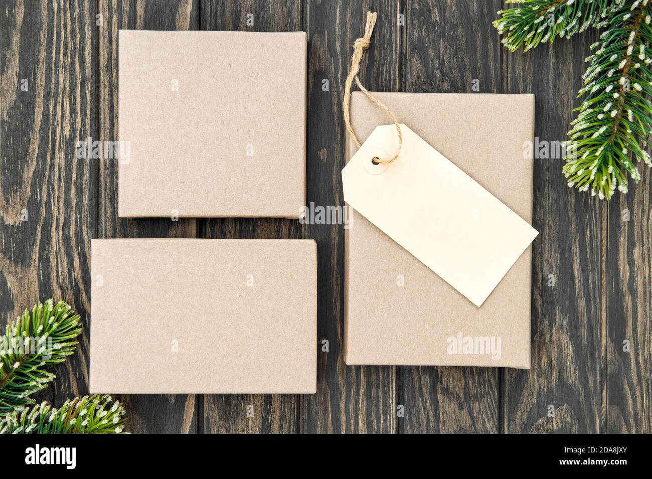 Natale scatole regalo artigianato carta tag su sfondo di legno Foto Stock