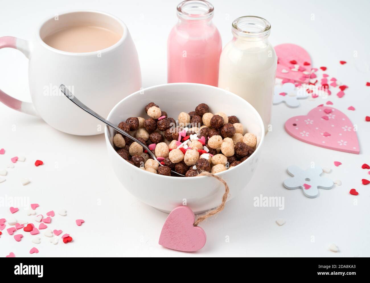 Palle di cereali e bevande a base di latte per la colazione su un sfondo romantico. Foto Stock
