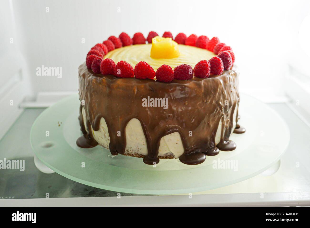 Torta intera con fragole e crema di cioccolato che gocciola sui lati. Foto Stock