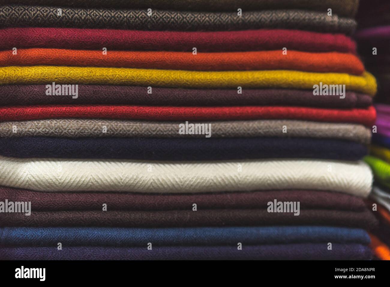 primo piano di tessuto colorato, un mucchio di tessuto di cashmere, una pila di vestiti colorati, un mucchio di vestiti Foto Stock