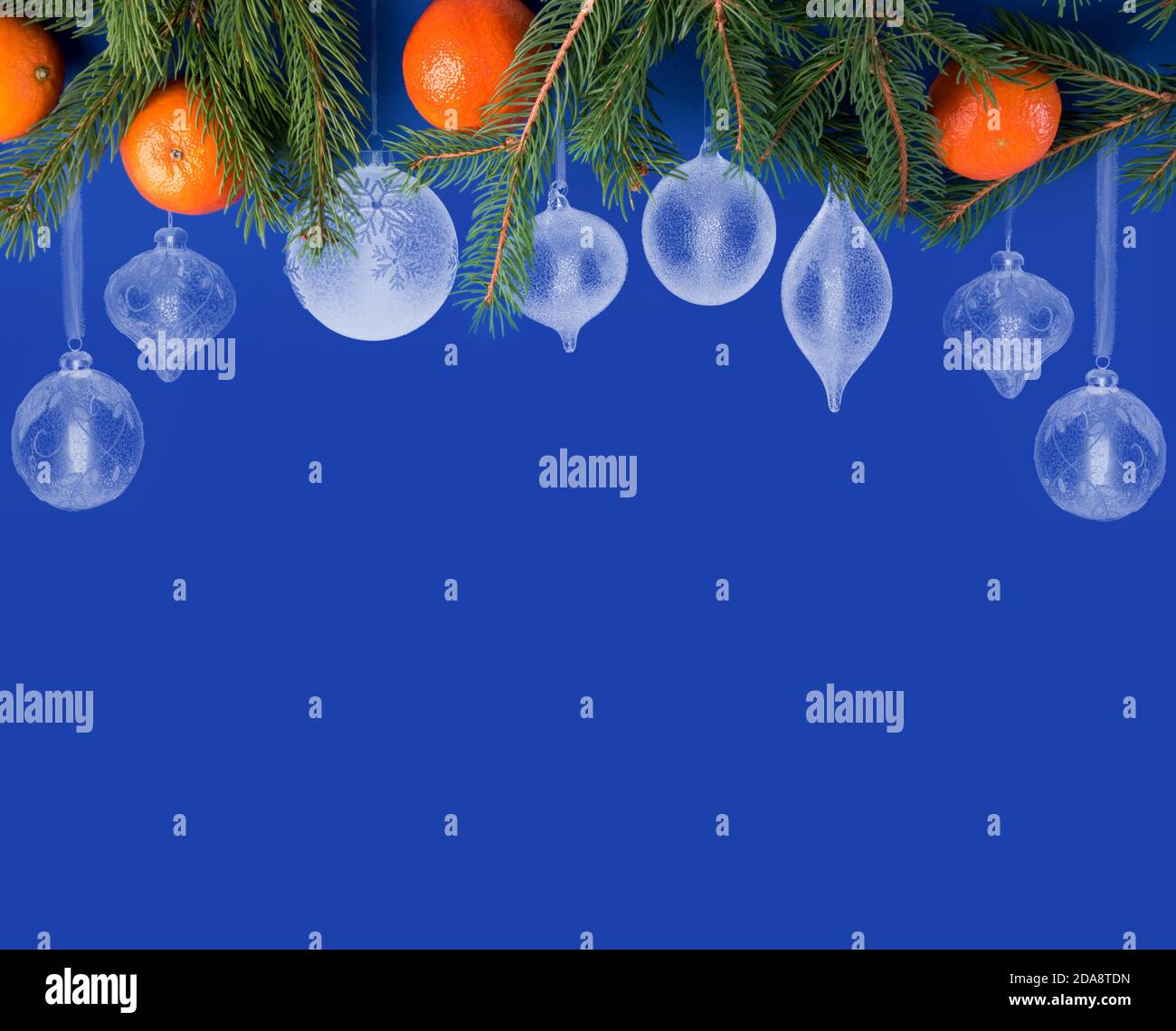 Sfondo di Natale blu con bordo decorato di palline bianche di Natale di forme diverse e con rami e mandarini di abete rosso Foto Stock
