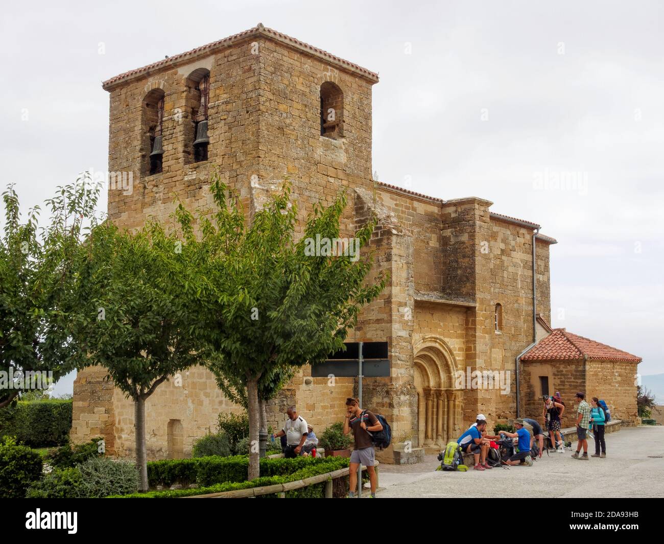 I pellegrini godono di una meritata pausa sul Camino presso la Chiesa di San Andrés (Iglesia) - Zariquiegui, Navarra, Spagna Foto Stock