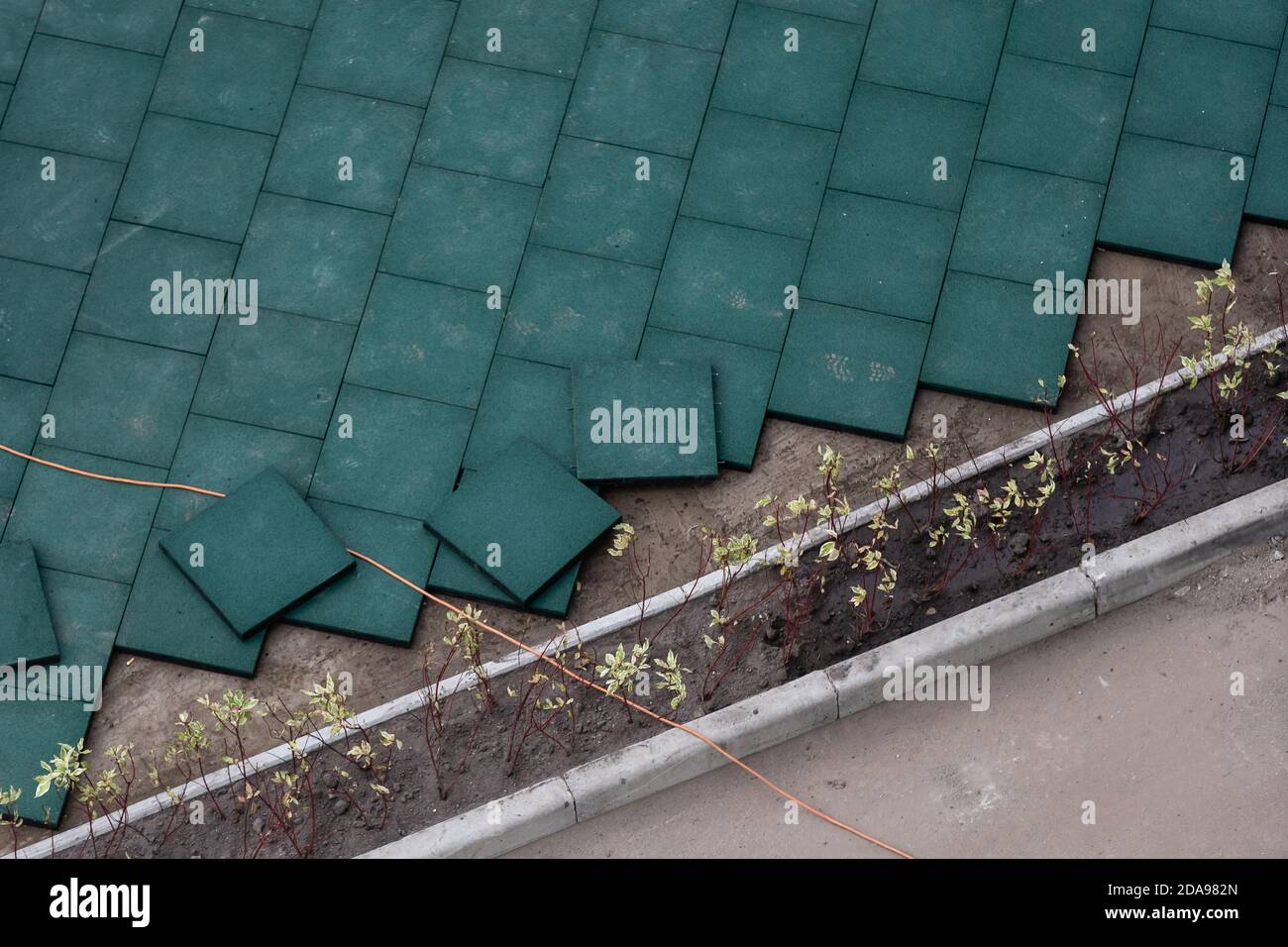 Installazione di pavimentazione in gomma sintetica EPDM elastica su asfalto  esistente come pavimento per giochi. I tappetini di sicurezza EPDM riducono  il rischio di lesioni Foto stock - Alamy