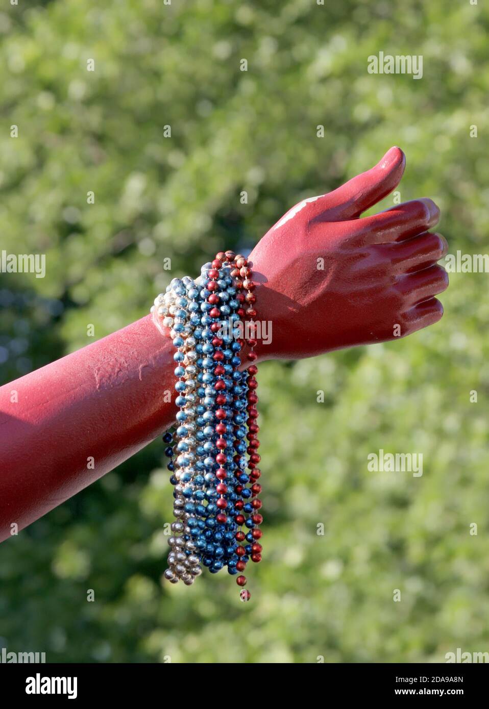 Una mano manichino rossa che mostra perle colorate. Foto Stock