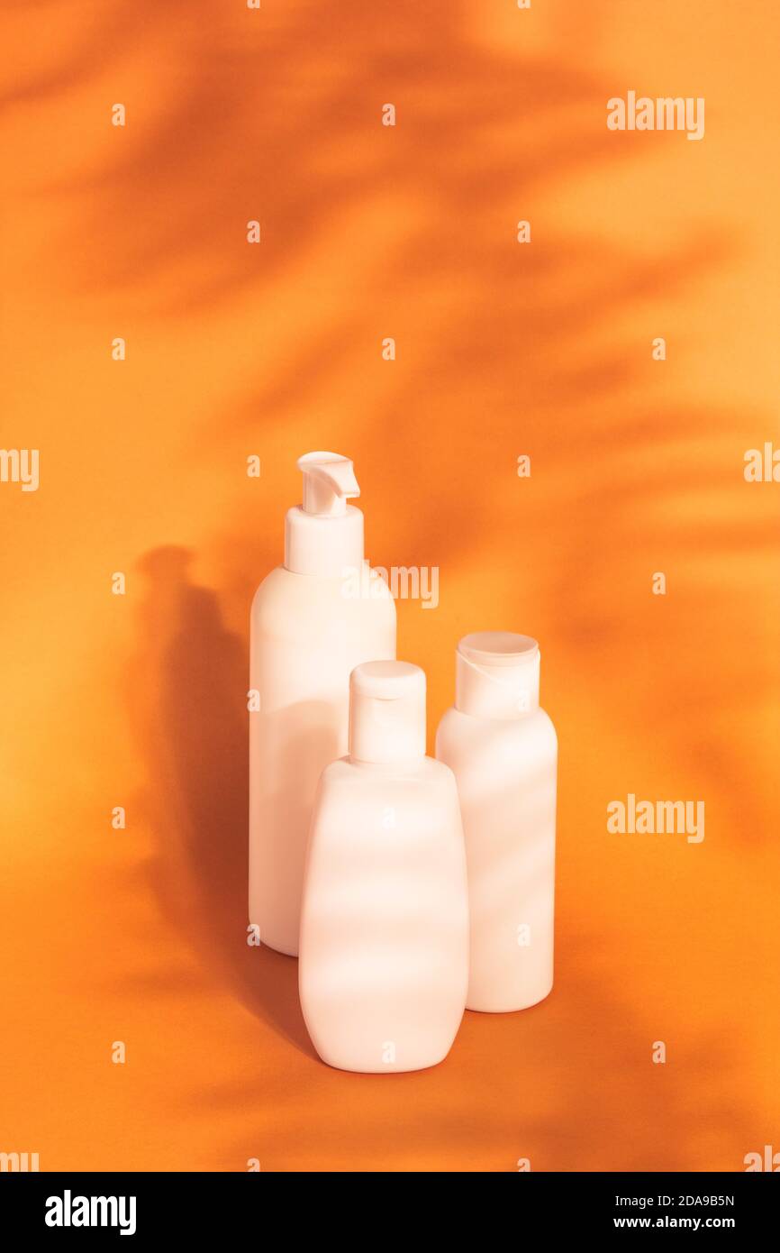 Set di prodotti cosmetici eco-compatibili con le foglie di felce ombra su sfondo beige. Flacone dispenser, tubo di crema. Branding, etichette e imballaggi Foto Stock