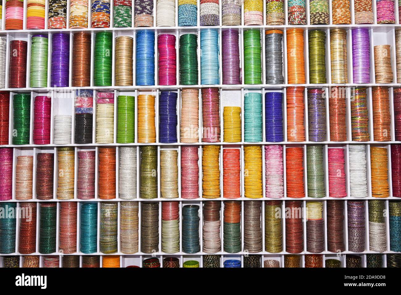 Stack di frizzante colorati bangle indiani in Jahari bazaar in Rajasthan, India del Nord. Varietà di vetro, metallo, bagli Lac. Donna accessori gioielli. Foto Stock