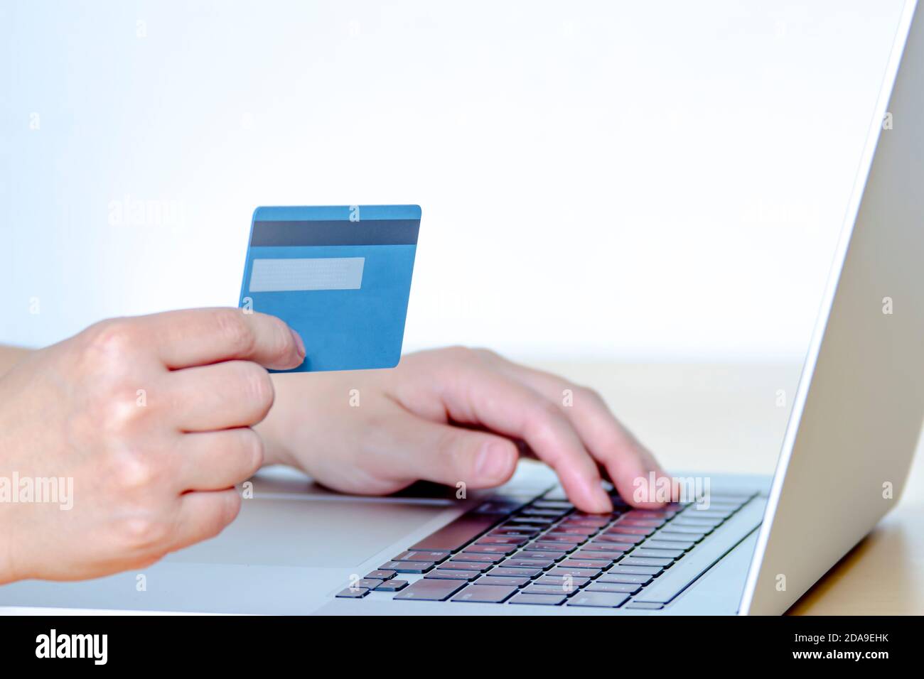 Una persona che acquista online con una carta di credito e un computer portatile. Foto Stock
