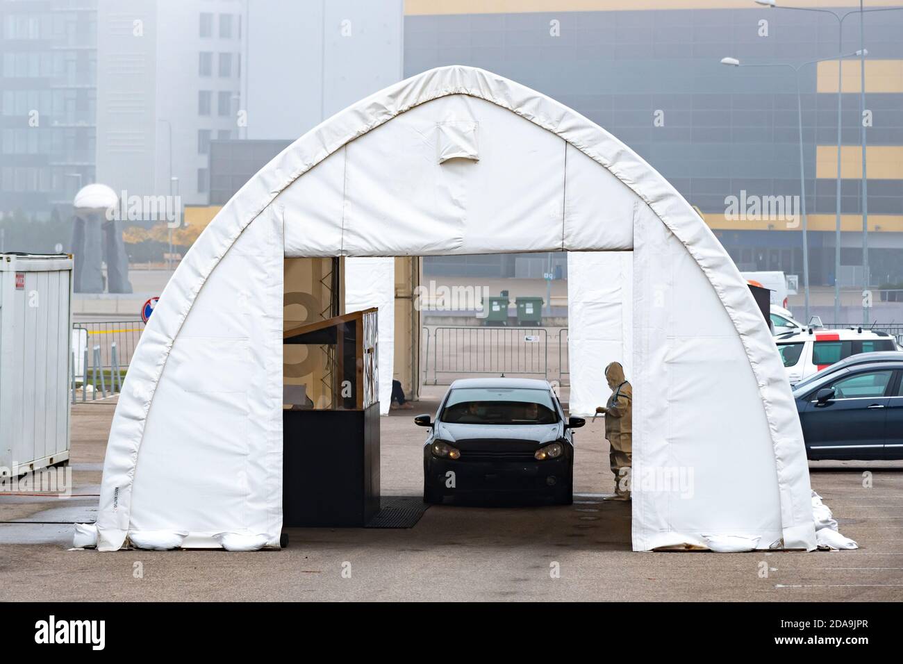 Stazione mobile di test tenda, hot spot per test con tampone durante l'epidemia di Coronavirus o COVID19 con paramedico e auto Foto Stock