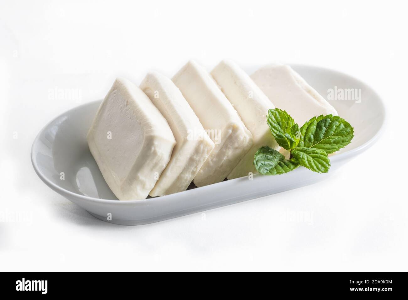 Formaggio arabo Nabulsi su piatto bianco su fondo bianco Foto Stock