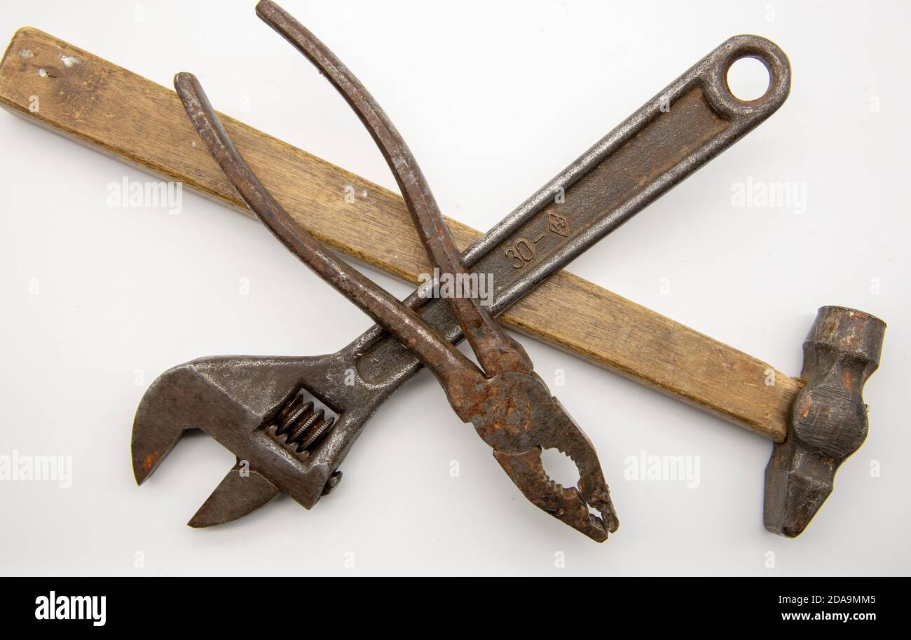 Set di vecchi attrezzi, martello, chiave e pinze su fondo bianco. Foto Stock