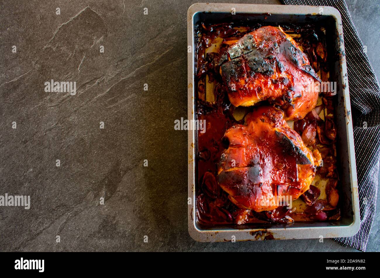 spalla di maiale fresca alla griglia su una teglia da forno dall'alto isolato su un tavolo Foto Stock