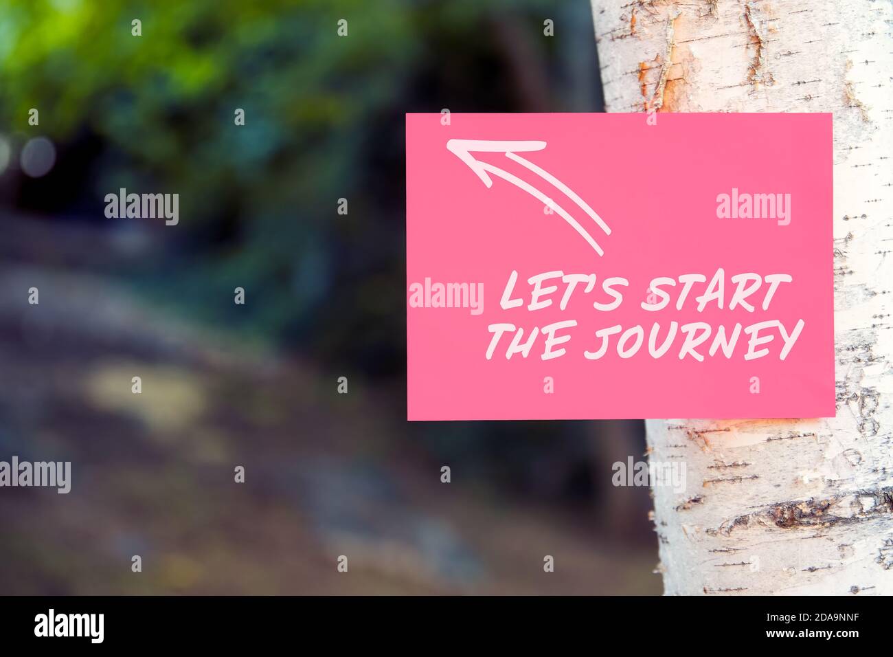 Iniziamo la citazione motivazionale o motivazionale di viaggio scritta su carta su un albero in natura. Foto Stock