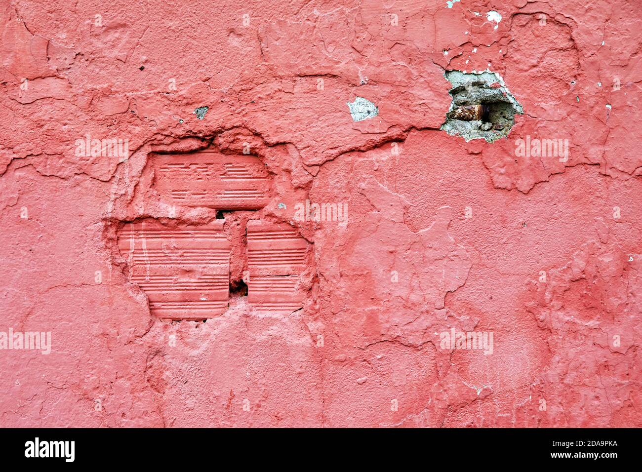 Parete rosa di cemento intemperie e fessurato come sfondo Foto Stock