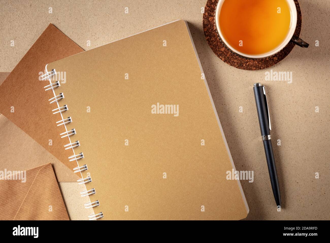 Concetto di journaling. Giornale di carta marrone, top shot su una scrivania con una tazza di tè e una penna, il concetto di scrittura libera Foto Stock