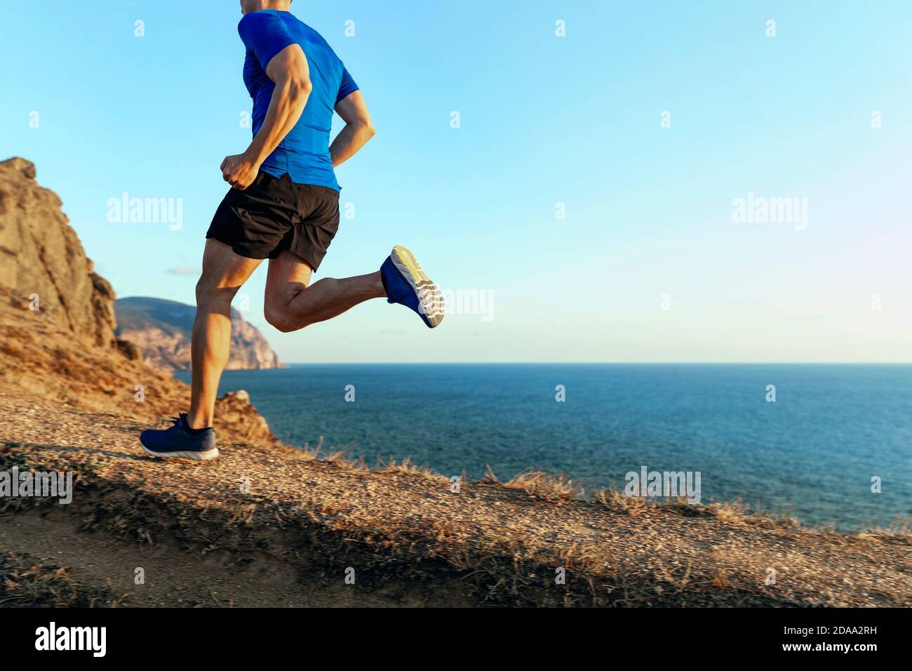 atleta corridore pista di montagna in cielo e mare di sfondo al tramonto Foto Stock