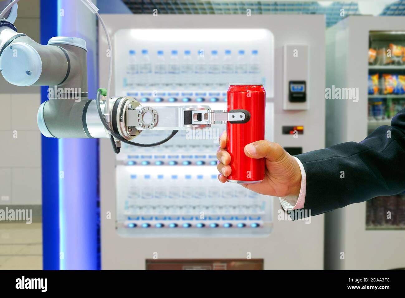Primo piano lattina di soda rossa robotica per l'invio a. uomo d'affari con distributore automatico intelligente di bevande Foto Stock