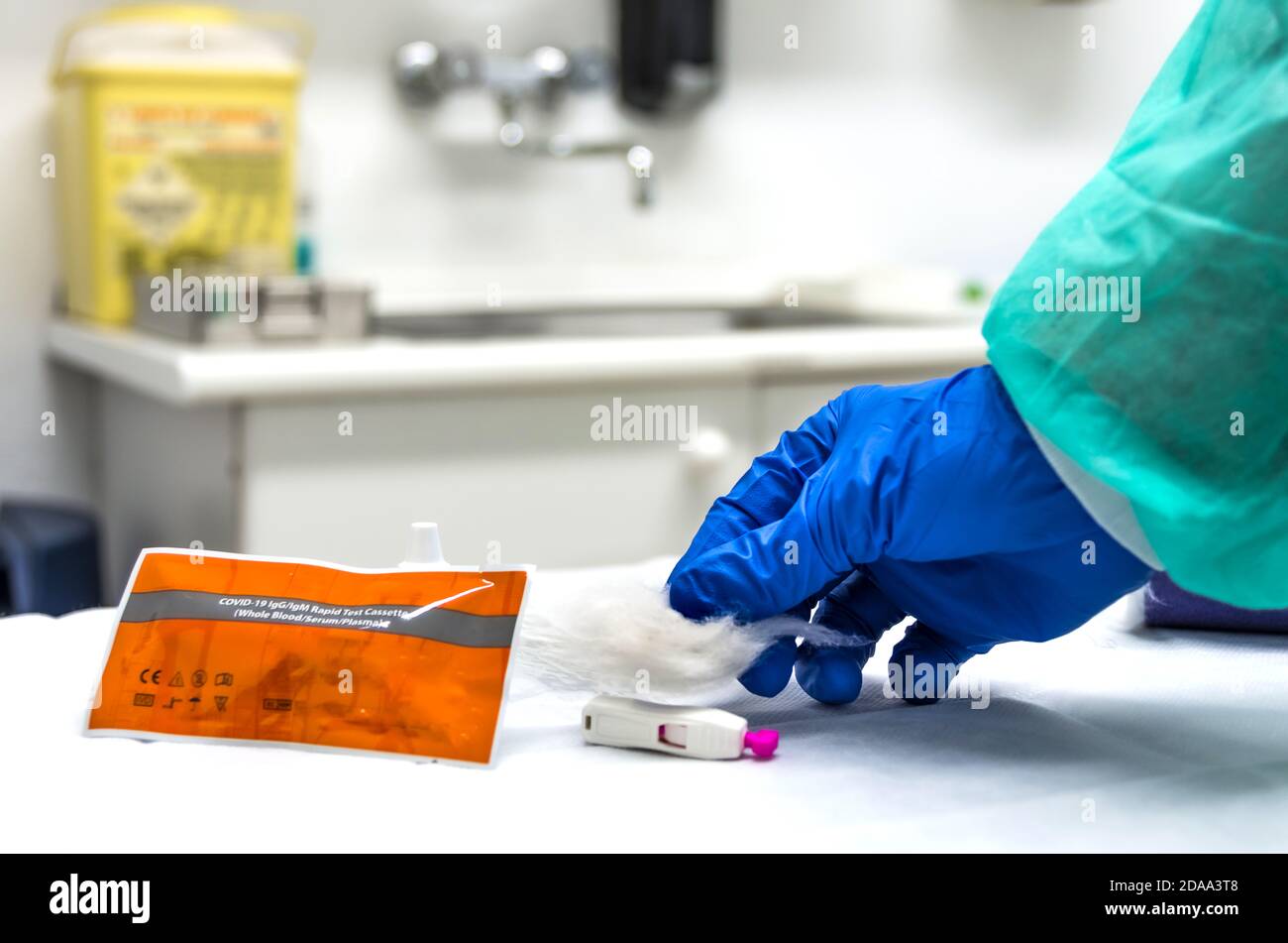 Mani di un infermiere con attrezzature di protezione individuale e cotone, in fase di raccolta del sangue per effettuare un test rapido per la covid-19(coronavirus); Foto Stock