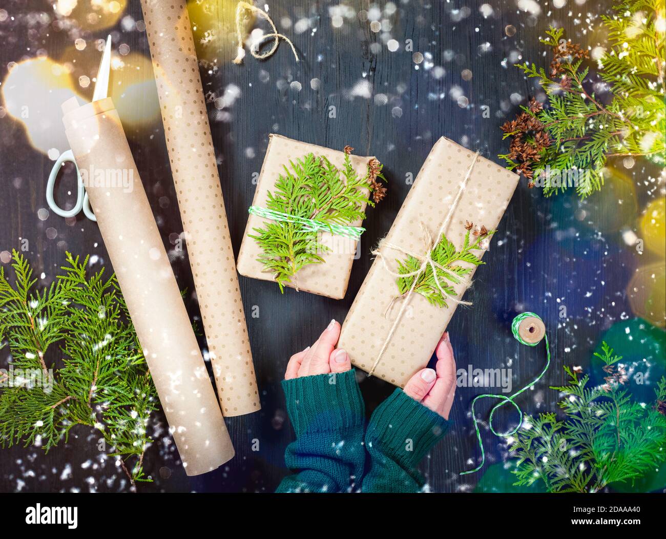 Natale senza sprechi. Regali di Natale avvolti in carta artigianale con rami thuja. Belle luci di Natale. Vista dall'alto Foto Stock