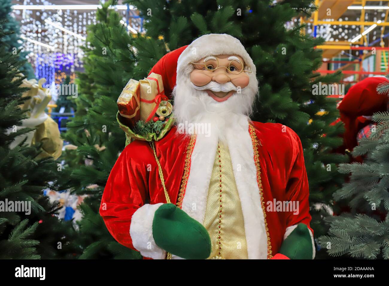 Divertente Babbo Natale sorridente in un cappello rosso, bello Capodanno e Natale giocattolo, decorazioni. Natale Natale inverno shopping, vendita. Negozio di giocattoli Foto Stock
