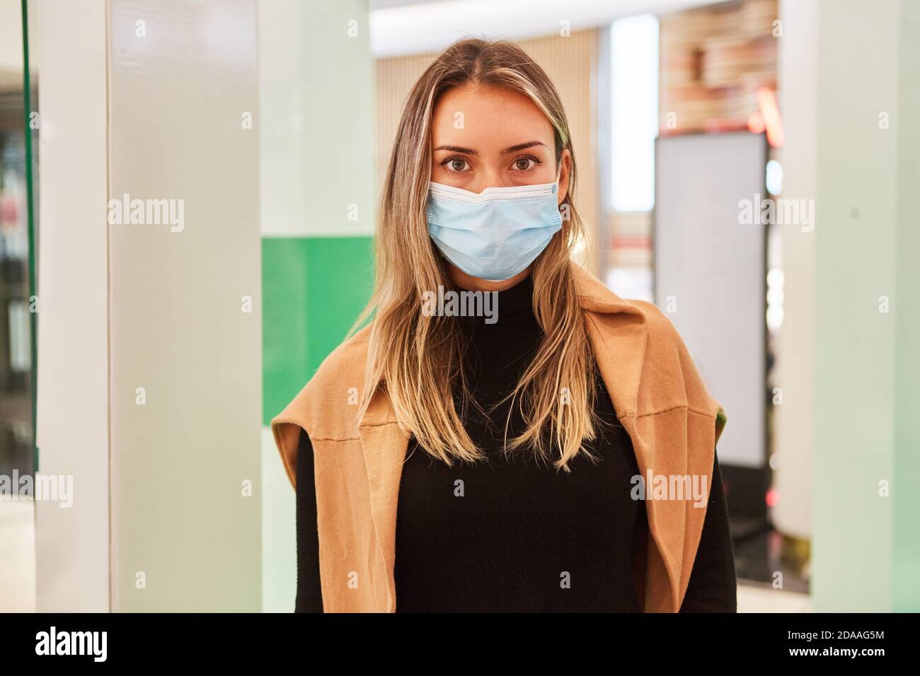 Cliente con maschera a causa della pandemia di Covid-19 nel centro commerciale durante lo shopping Foto Stock